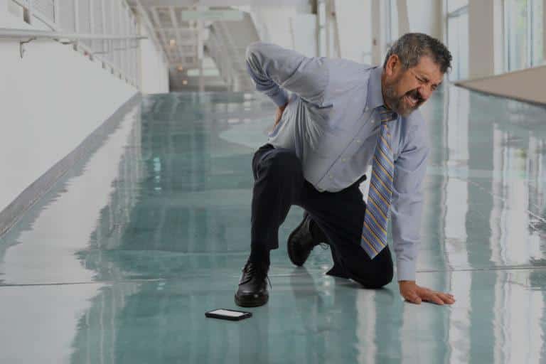 Homme en cravate qui souffre et se tient le dos