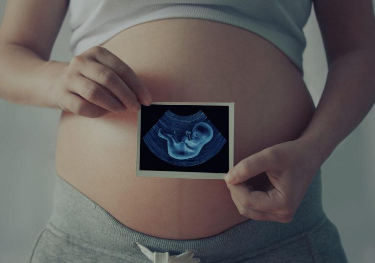 placenta lien mere foetus femme enceinte qui montre une photo de son échographie