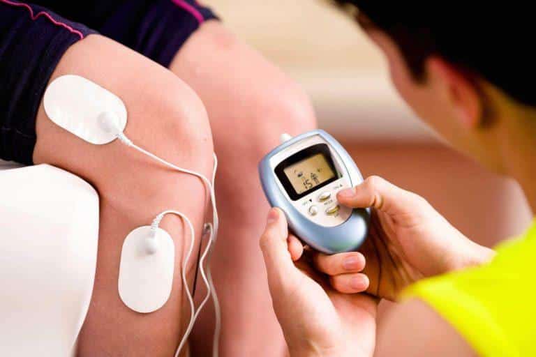 electrostimulation-avis personne qui tient un appareil d'éléctrostimulation