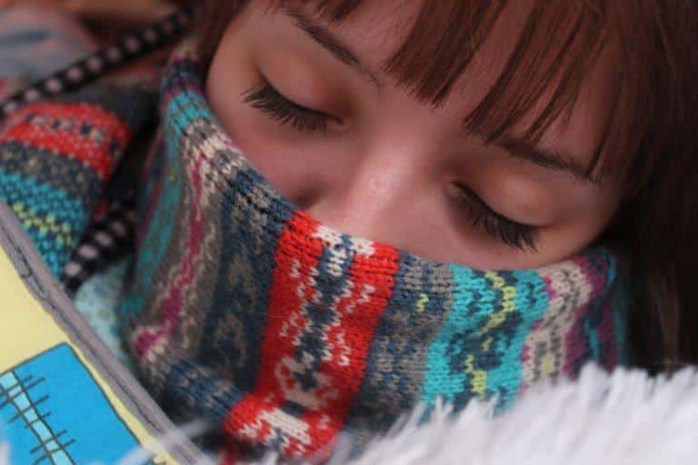 coronavirus ou grippe Femme qui dort et qui porte une écharpe sur sa bouche et son nez